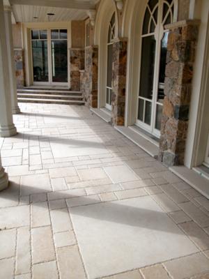 This outdoor patio is tiled in custom sized limestone pavers. The large pieces complement the size of the overall structure. The smaller size piece create interest in such a large area.